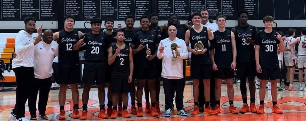 Cal High Varsity Basketball team holding trophies on the court